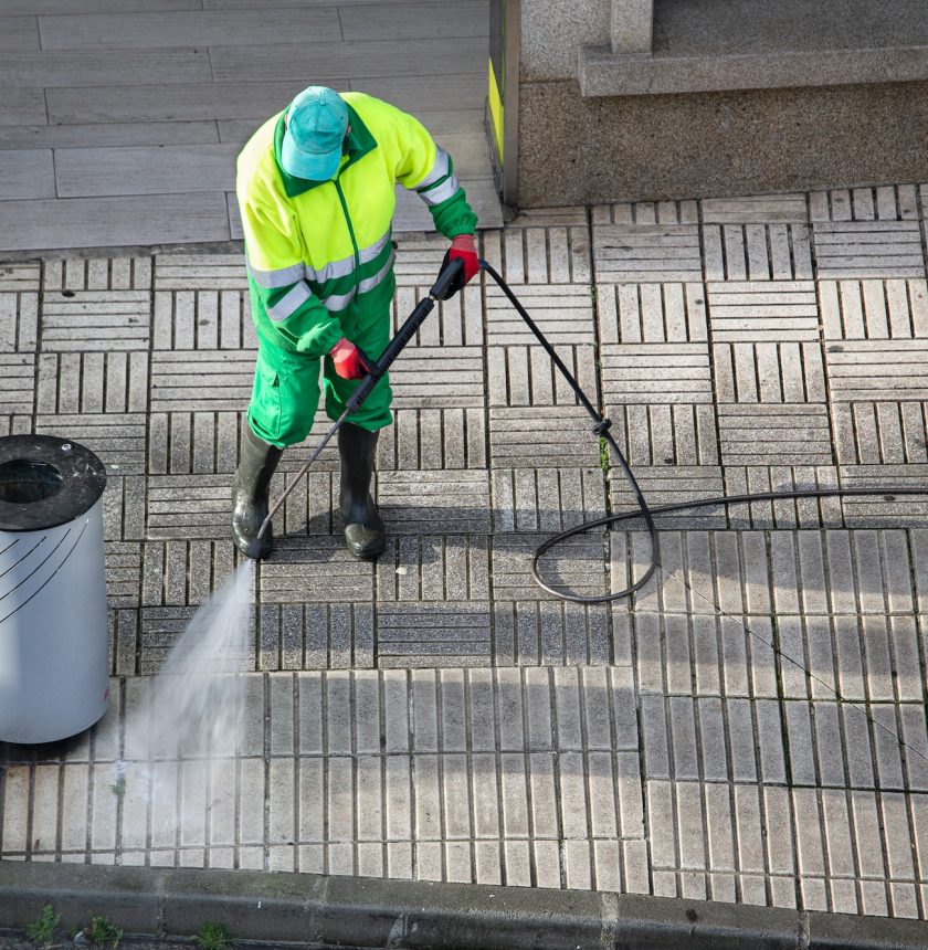 Sweeper cleaning a street sidewalk with high pressure water jet machine